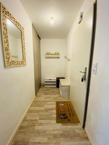 - un couloir avec une salle de bains pourvue d'un miroir et d'une porte dans l'établissement Maison familiale proche plage et commerces, à Saint-Nazaire