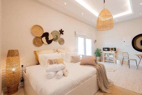 una camera da letto con un grande letto bianco con asciugamani di Voyage Studio In Ansam With Golf Course View a Abu Dhabi