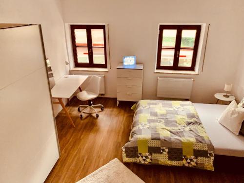 帕紹的住宿－FELIX LIVING 7, modern & cozy, geilste Dachterrasse der Stadt, 6 Schlafzimmer，卧室配有一张床、一张书桌和窗户。