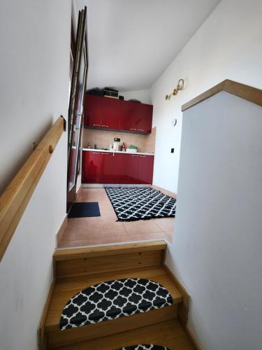 a stairway with red cabinets and black and white mats at Cloud Apartment Gozsdu Budapest in Budapest