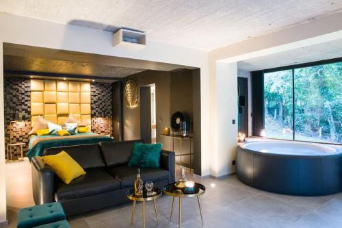 - un salon avec un canapé et une baignoire dans l'établissement Buenas Noches Villa Standing piscine & wellness, à Boncelles