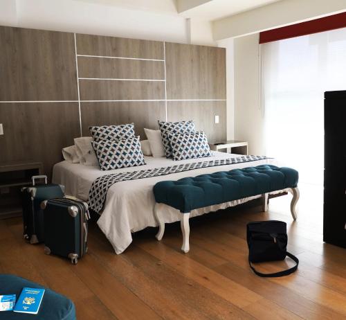 Un dormitorio con una cama grande con un banco en ella. en Capital Luxury Apartments & Offices, en Ciudad de México