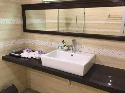 - un lavabo blanc sur un comptoir noir dans la salle de bains dans l'établissement Maxwell inn, à Taiping