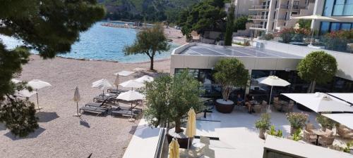 an overhead view of a beach with umbrellas and a building at DIN Ljubic in Mimice