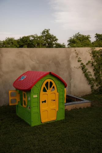 a toy dog house with a red roof and a door at Vila Lio & Restaurant Devojacki Bunar in Novi Vladimirovac
