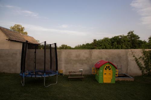 a childs play house and a trampoline in a yard at Vila Lio & Restaurant Devojacki Bunar in Novi Vladimirovac