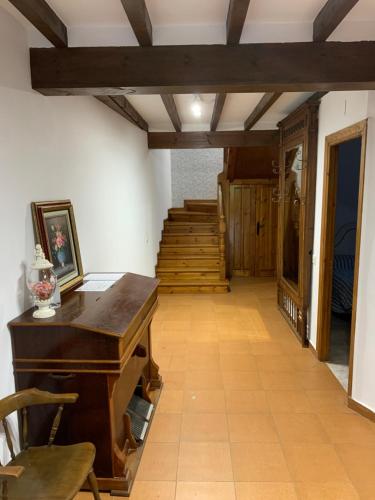 an empty room with a piano and a staircase at Casa Rural Erre Q Erre in Oreña