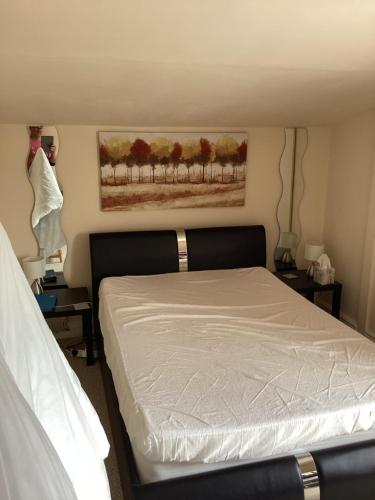 ein Schlafzimmer mit einem weißen Bett und zwei Nachttischen in der Unterkunft Holm On The Lane in Birkenhead