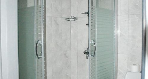 Dorana Residence في Geunyeli: حمام مع دش زجاجي مع مرحاض