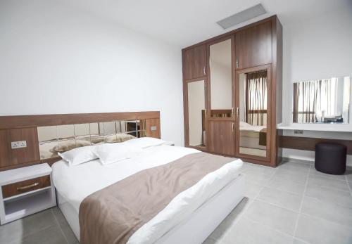 Dorana Residence في Geunyeli: غرفة نوم بسرير ابيض كبير ومرآة