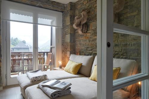 1 dormitorio con sofá y pared de piedra en Port Luxe by FeelFree Rentals, en Naut Aran (Alto Arán)