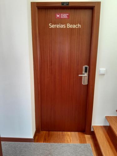een houten deur met een bord dat geheimen strand leest bij Cabo do Mar Apart.- Sereias Beach in Espinho
