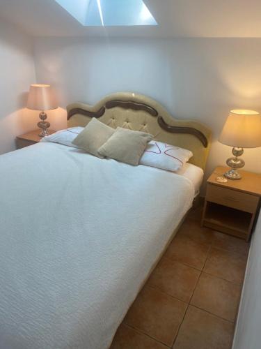 a bedroom with a large white bed with two lamps at Beachfront two bedroom apartment Angelina in Ðenovići