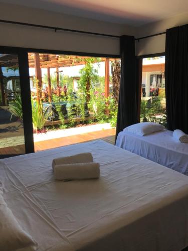 1 dormitorio con 2 camas y ventana grande en Barong EcoVilla, en Barra Grande