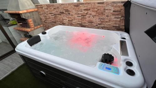 een wit bad gevuld met water in een kamer bij Estudio Agradable, Con Jacuzzi, Terraza y Barbacoa, Totalmente independiente in Corralejo