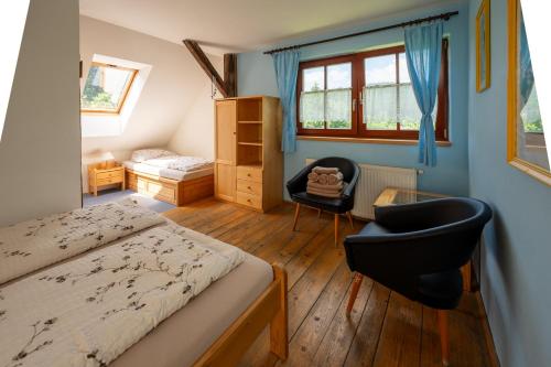 a bedroom with a bed and a chair in a room at Penzion pod Pralesem in Velké Karlovice