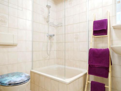 y baño con bañera, aseo y toallas púrpuras. en Ferienwohnung mit Garten, en Ehrenkirchen