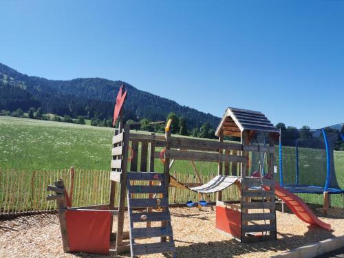a playground with a slide and a swing at Kummererhof in Itter