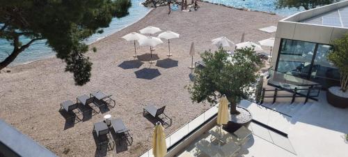 an overhead view of a beach with chairs and umbrellas at DIN2 Ljubic in Mimice
