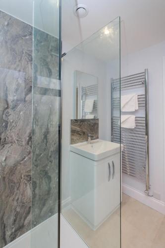 a bathroom with a sink and a glass shower at Primrose Cottage, Leiston, near Sizewell, Thorpeness and Aldeburgh - Managed by Aldeburgh Coastal Cottages in Leiston