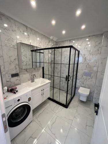 a bathroom with a sink and a washing machine at Reis apart in Trabzon