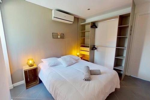een slaapkamer met een wit bed en 2 handdoeken bij Appartement avec terrasse proche Nice et Monaco in Contes
