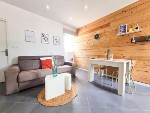 een woonkamer met een bank en een tafel bij Appartement avec terrasse proche Nice et Monaco in Contes