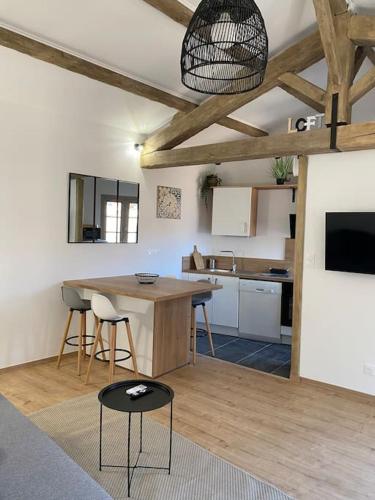 une cuisine avec une table et des chaises dans une pièce dans l'établissement Le petit loft des halles, à Béziers