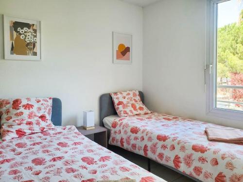 - une chambre avec 2 lits et une fenêtre dans l'établissement *Le Carpe Diem, Appartement 2 chambres, piscine, 2 Parking, Clim*, à Montpellier