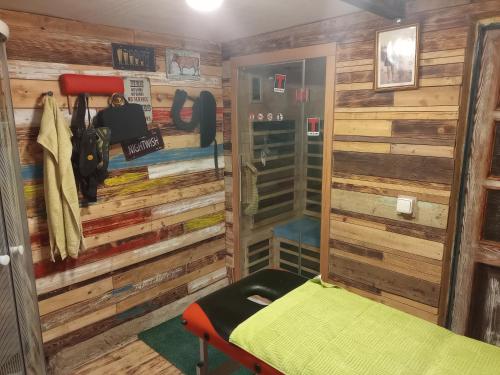 um quarto com paredes de madeira e uma cama em Apartmán Dobrná 
