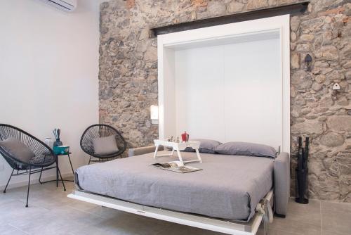 a bedroom with a bed and a stone wall at Labiena 12 Lago maggiore in Laveno-Mombello