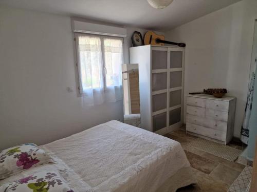 um quarto com uma cama, uma cómoda e uma janela em Petite maison sympathique em Gargas