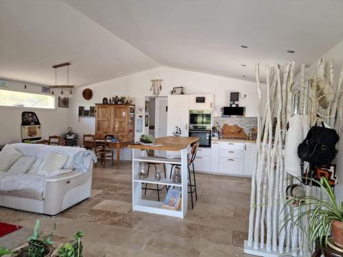 a kitchen and living room with a table and a couch at Petite maison sympathique in Gargas
