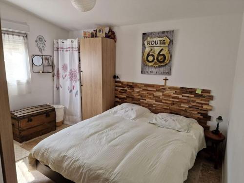 um quarto com uma cama e uma parede de tijolos em Petite maison sympathique em Gargas
