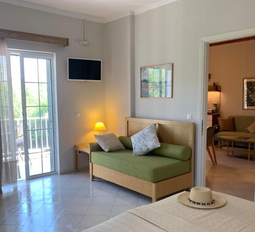 a living room with a green couch and a television at Irene Villas in Arillas