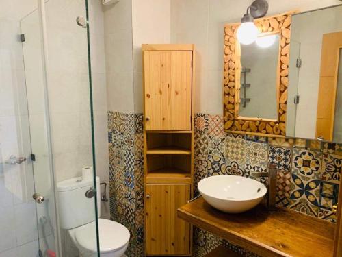 bagno con servizi igienici, lavandino e specchio di Séjour avec piscine proche de la mer a Tamaris
