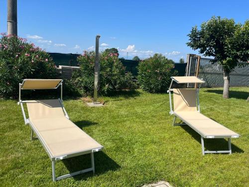 two benches sitting on the grass in a yard at B&B Villa Verona Bike in Buttapietra
