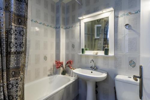 y baño blanco con lavabo, bañera y lavamanos. en Nikolas house, en Skopelos Town