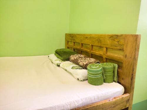 een slaapkamer met een bed met groene muren bij BARRIL GREEN HOMESTAY in Batuan