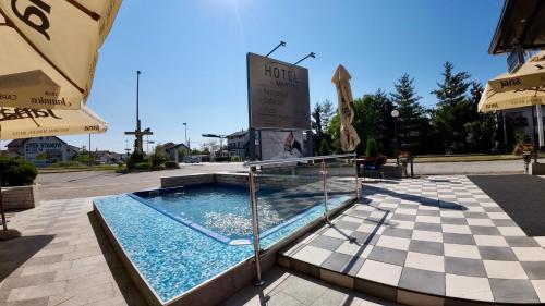 een zwembad voor een gebouw met een bord bij Hotel Martini Zagreb Hotel and Restaurant in Sesvete