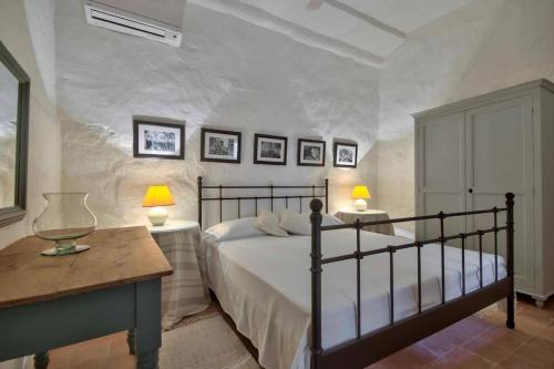 1 dormitorio con 1 cama, 2 mesas y 2 lámparas en Casa Mezzodì' - Luxurious 18th C. Farmhouse with Gardens & Pool, en Kerċem