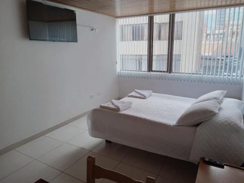 - une chambre avec un lit et une grande fenêtre dans l'établissement HOTEL SUAREL CENTER, à Duitama
