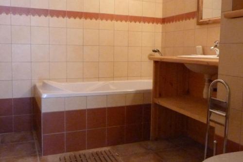 une salle de bain avec une baignoire et un lavabo dans l'établissement Montseti - 3 bedroom ski-in ski-out apartment, à Sainte-Foy-Tarentaise