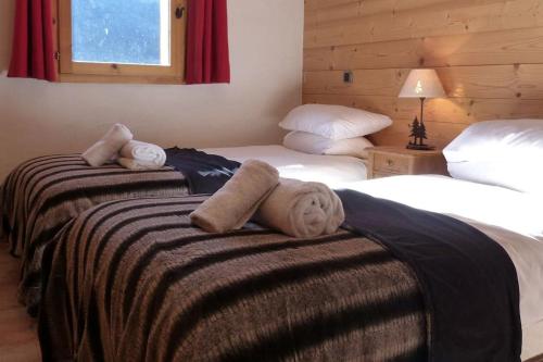 - 2 lits dans une chambre d'hôtel avec des serviettes sur le lit dans l'établissement Montseti - 3 bedroom ski-in ski-out apartment, à Sainte-Foy-Tarentaise