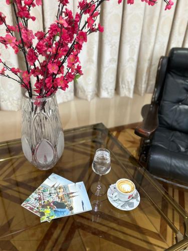 a glass vase with pink flowers on a glass table at Hotel Martini Zagreb Hotel and Restaurant in Sesvete