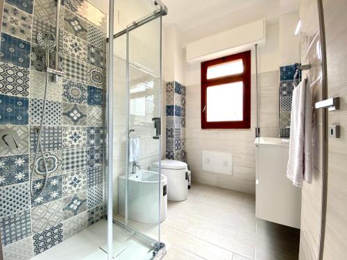 bagno con doccia in vetro e servizi igienici di Casa Perla Marina sul mare a Castellammare del Golfo