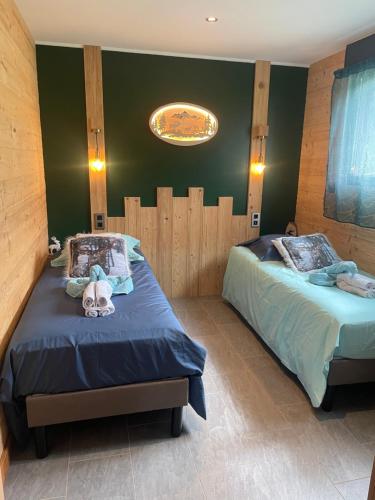 a bedroom with two twin beds and a ceiling at Nature Cottage Vosges Spa Le Cerf in Anould