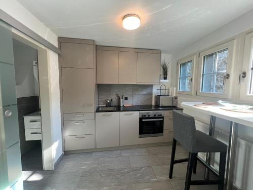 a kitchen with white cabinets and a table and a chair at House on historic city wall - Freihofapartments in Brugg