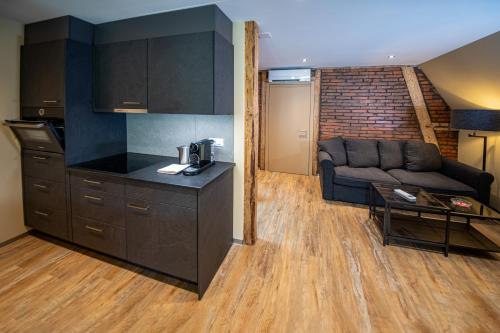 a kitchen and a living room with a couch at Swiss Inn & Apartments in Interlaken