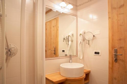 a bathroom with a sink and a mirror at Hotel Malder in Soraga